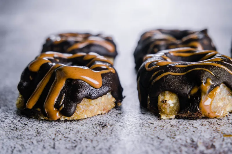Roh-vegane Mini Donuts mit Schokoladenglasur und Mandelmus