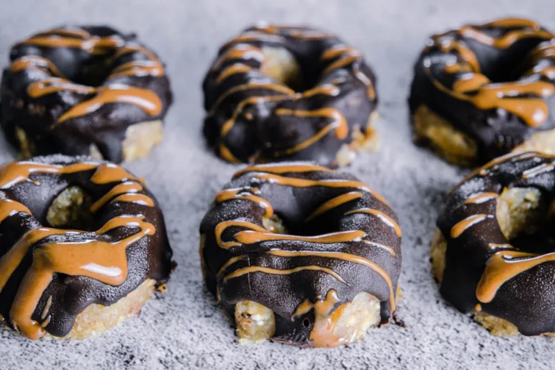 Roh-vegane Mini Donuts mit Schokoladenglasur und Mandelmus